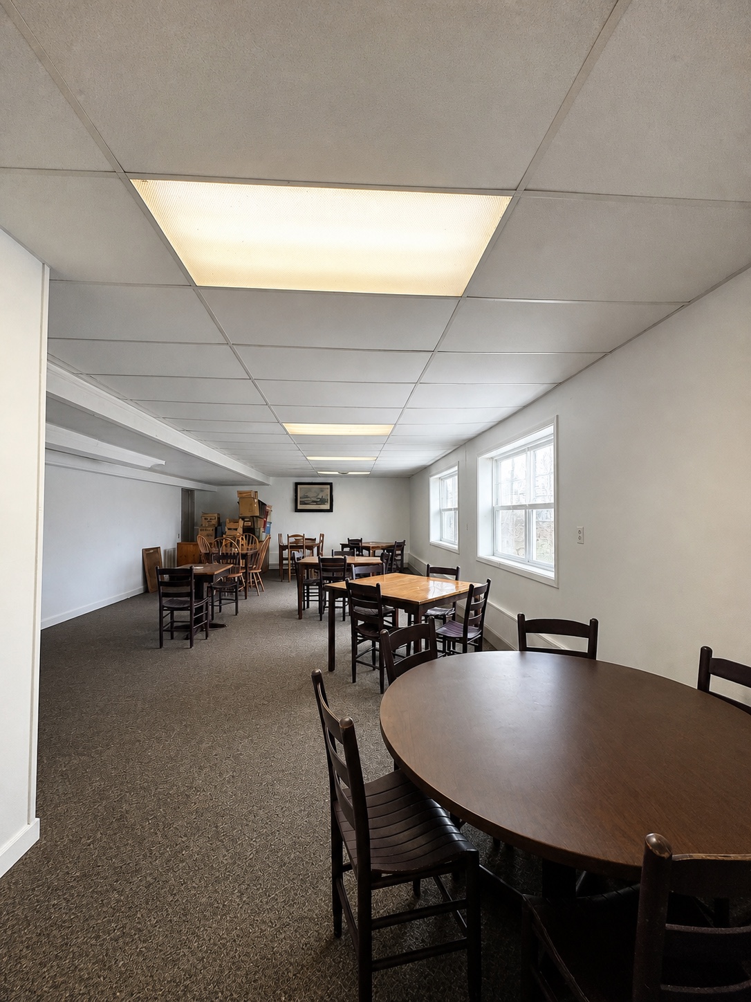 Additional rear dining room with tables, chairs, and windows