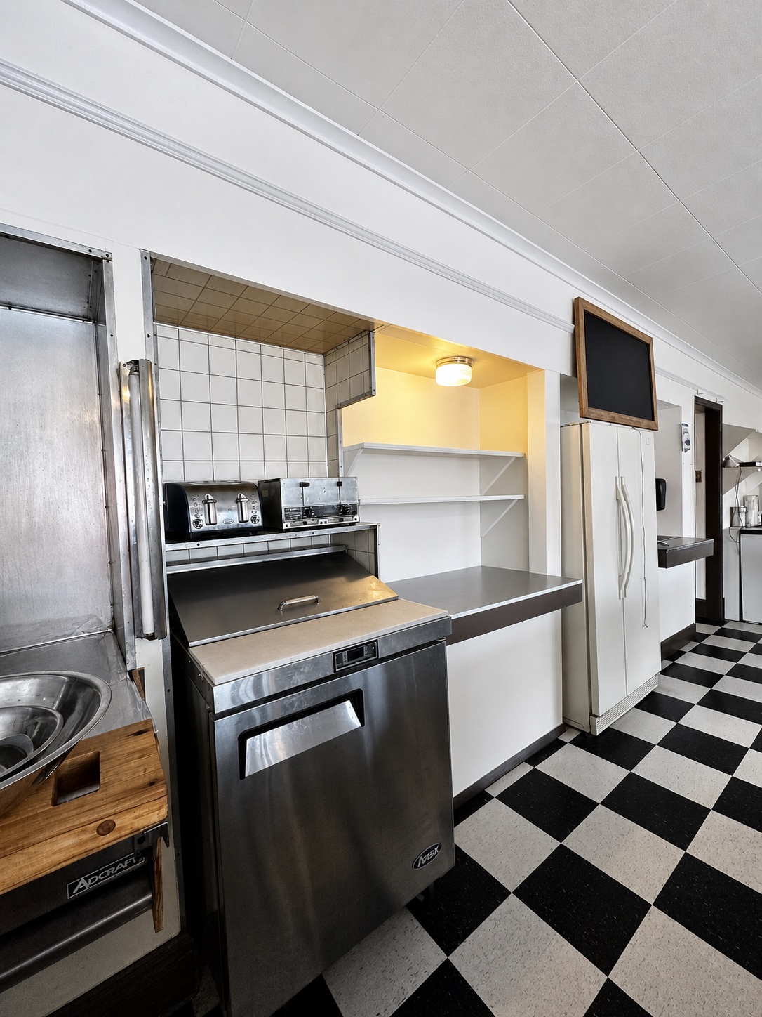 Restaurant preparation area with stainless equipment and checkerboard floor